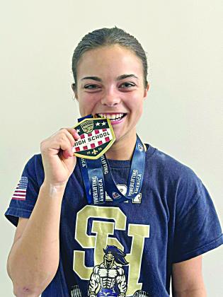 Adeline Launey shows off her medal for winning a national powerlifting meet in New Orleans. (Photo courtesy of Sacred Heart Athletics)