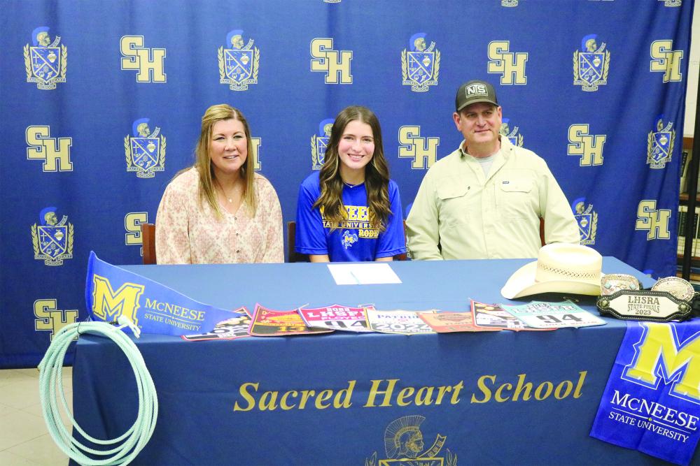 Mackenzie Floyed (center) is pictured with her mother, Ann; and father, Robert, during a signing ceremony on Monday, March 25, at Sacred Heart. (Gazette photo by Tony Marks)