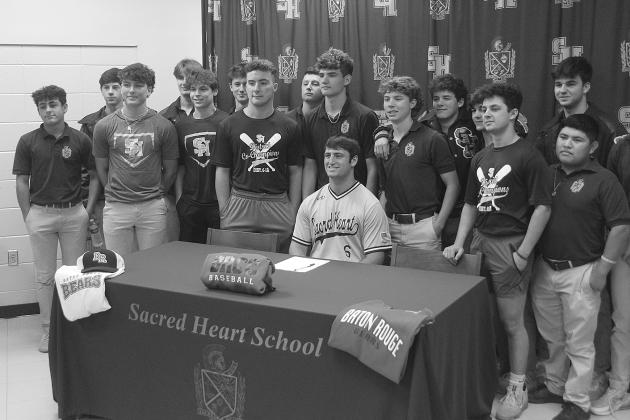 While flanked by members of the Sacred Heart baseball team, Briggs Ardoin (seated) is pictured after signing to continue his playing career at Baton Rouge Community College. Among those also pictured are Ellis Fusilier, Parker Feucht, Hayden Droddy, Sam Veillon, Nick Fontenot, Everett Johnson, John Michael Duplechin, Jackson Bruney, Boyce Schexnider, Brad Fusilier, Wade Pitre, and Sam Richardson.