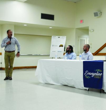Cleco president and CEO Bill Fontenot (standing) delivers remarks during a meeting with the Evangeline Chamber of Commerce on Monday, September 26, at the Ville Platte Northside Civic Center. Seated from left are Cleco Energy Efficiency Consultant Gary Guidroz and Cleco Vice President of Customer Service Andre Guillory. (Photo by Mable Foreman)