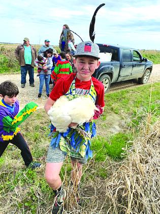 Wesley Matt is shown above with his prized chicken following a chase during the 2022 Duralde Children’s Mardi Gras run.
