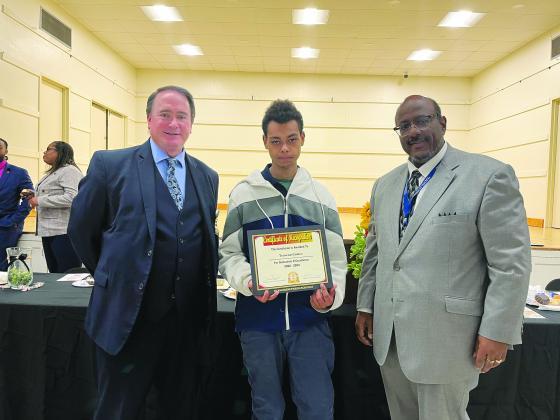 OUTSTANDING WORK-BASED STUDENT OF THE YEAR RECOGNIZED - Traveon Cortez of Basile High School, who worked at Rhea’s Specialty Meats in Baslie, was announced as the Outstanding Work-Based Student of the Year during the annual appreciation luncheon held Thursday, March 16. He is shown with Assistant Superintendent Mike Lombas (left) and Superintendent Darwan Lazard (right). (Gazette photo by Heather Bogard