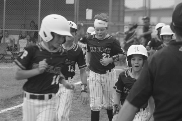 Ville Platte’s Brant Lejeune (14), Kameron Guillory (12), Sam Blanchard (22), and Eli Fontenot (27) react after Luke Vidrine launches a first-inning two-run home run against Oakdale in the Dixie Youth Majors District 7 Championship Game on Sunday, July 9. The team now competes in the state tournament in Metairie. (LSN photo by Tony Marks)