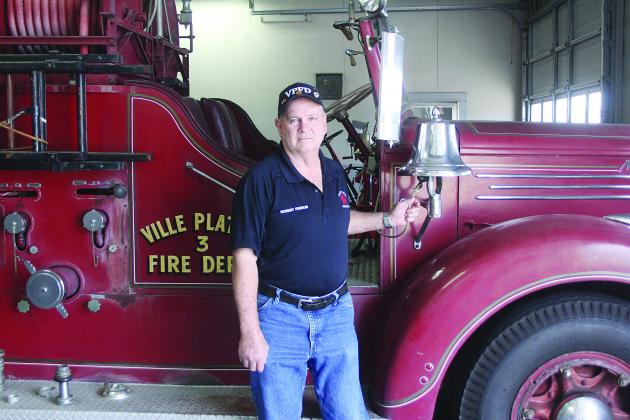 Robert Perron, a 50-year veteran of the Ville Platte Fire Department, is pictured as he rings he bell on fire truck No. 3. (Gazette photo by Tony Marks)