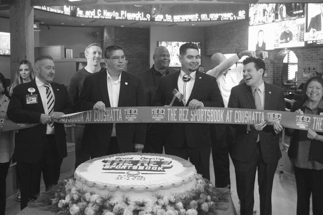 Flanked by members of the Coushatta Tribal Council Crystal Williams, Kristian Poncho, Loretta Williams, and Kevin Sickey, Chairman Jonathan Cernek (center) cuts the ribbon at the grand opening of The Rez Sportsbook in Kinder. Pictured from left in the back are former NFL players Owen Daniels, Rickey Jackson, and Drew Pearson. (Gazette photo by Tony Marks)