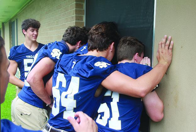 Several Sacred Heart seniors peer through the hospital window of Tim Fontenot to send him encouragement while in recover at Mercy Regional Medical Center. The seniors from Ville Platte High also visited. (Gazette photo by Tony Marks)