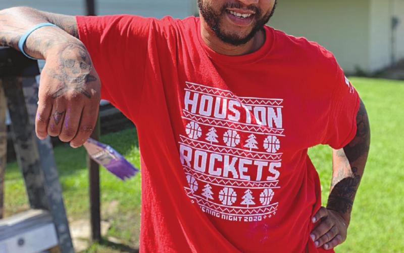Local artist Thaddaeus Arvie is pictured as he takes a break from painting a mural at the Martin Luther King Jr. Center. (Gazette photo by Nancy Duplechain)
