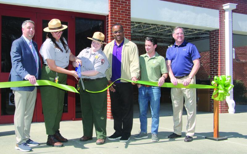 Cutting a ribbon marking the reopening of the Prairie Acadian Cultural Center on Friday were, from left, Scott Fontenot  Eunice mayor; Laura McDonald and Lainey Binnix, park rangers; Herman Fuselier, parish tourism director; Justin Lemoine, executive director of the Atchafalaya National Heritage Area; and Dwight Jodon, Eunice Rotary Club member. (LSN photo by Harlan Kirgan)