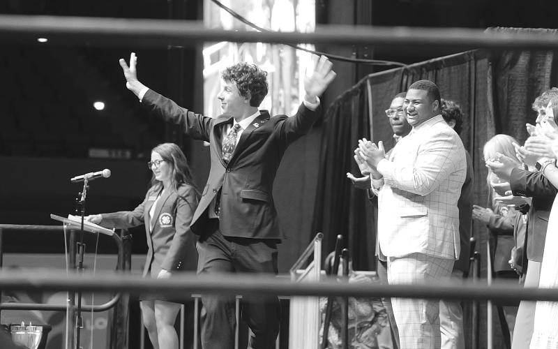 Dayton Pennington, of Avoyelles Parish, celebrates after being introduced as the new 4-H state president during an assembly at 4-H University on June 19, 2025. Looking on are, at left, outgoing president Breleigh Page, of Livingston Parish, and several other newly named officers of the organization. (Photo by Olivia McClure/LSU AgCenter)