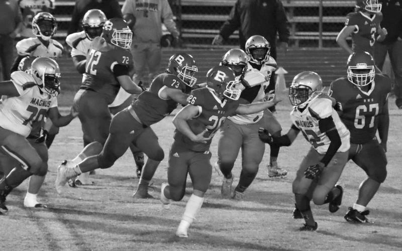 Ashton Deville (26) runs right at a Magnolia defender while Christian Bergeron (73) and Anphrony Guillory (67) play their respective roles in Basile’s galloping round one playoff win last week. (Photo by Nikki Johnson)