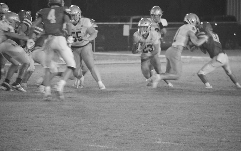 Kolton Lafleur (55) provides a block letting Jude Hebert (23) find some running room in Sacred Heart’s 17-14 win over Basile. (LSN photo by Rhett Manuel)