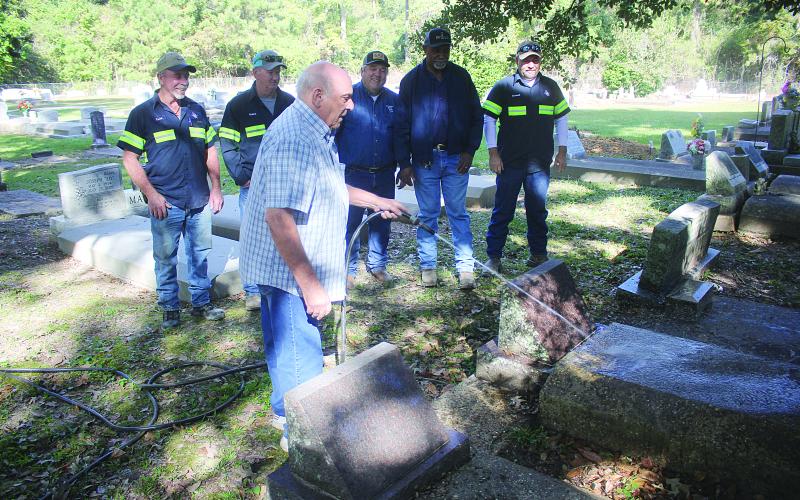 Roy Viscardis, the caretaker of Beaver Creek Cemetery, is pictured as he washes off a grave. Pictured from left behind him are Todd Sharpe, Robert Coker, Evangeline Parish Police Juror Tim Causey, Michael George, and Randall King. Not pictured is Farron Gordon. (Gazette photo by Tony Marks)