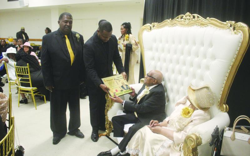 On behalf of the Evangeline Parish Police Jury, Jurors Daniel Arvie (standing left) and Darion Arvie (standing right) present a proclamation to Pastor Eradly Ben Sr. (seated left) and First Lady Lois Ben (seated right) in recognition for their 50 years of ministry to Antioch Baptist Church. (Gazette photo by Tony Marks)