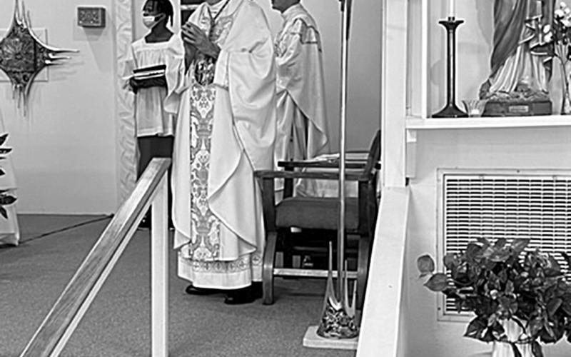 Bishop Douglas Deshotel sings along with The Gloria during the 75th Anniversary Mass of St. Joseph Church in Ville Platte. Pictured in the back is the church’s pastor, Fr. Tom Voorhies. (Gazette photo by Tony Marks)