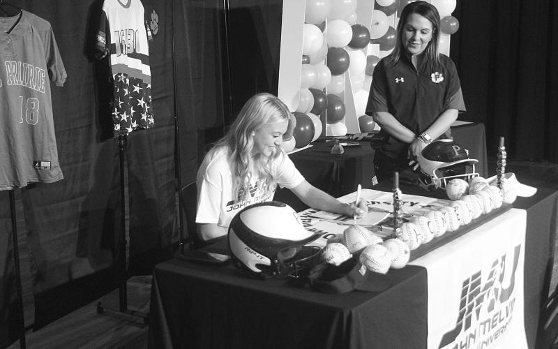 Alaina Boutte (seated) signs to play college softball for the John Melvin University Millers. She is the 17-year-old daughter of Dwana and Shane Boutte, of Pine Prairie. She signed on Thursday, January 26, inside the school’s auditorium. Standing in the photo is Pine Prairie’s head softball coach Alycia Hebert. (Gazette photo by Tony Marks)