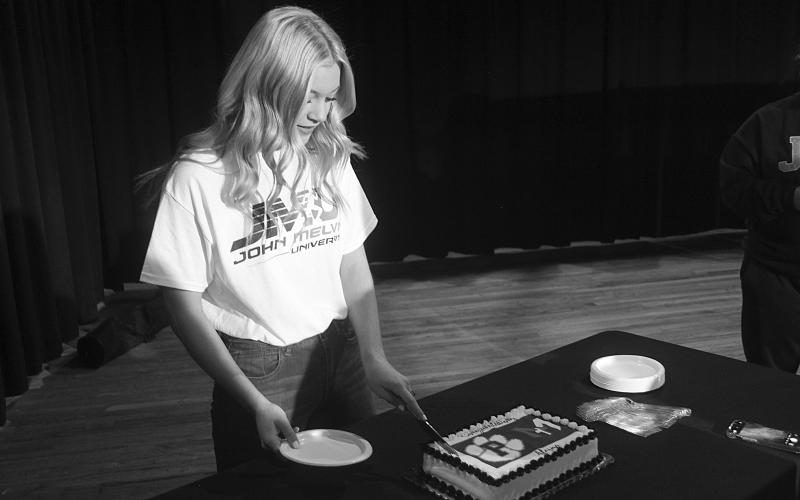 Alaina Boutte is pictured as she cuts the cake after signing to play softball for JMU in Crowley. (Gazette photo by Tony Marks)