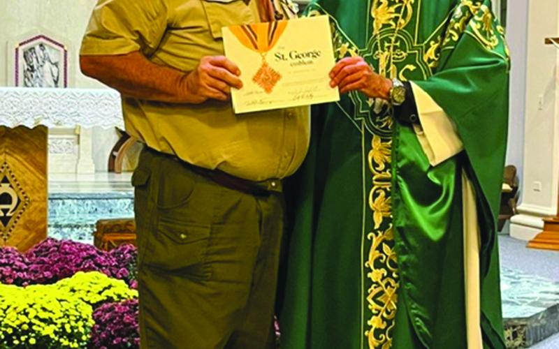 Brian Thompson of Basile (left) receives the St. George medal and certificate from Bishop Douglas Deshotel of the Diocese of Lafayette.