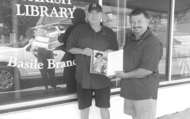 Ben Fontenot (left) and Greg Brown present a copy of Cajun and Creole Music Makers to the Basile branch of the Evangeline Parish Library.