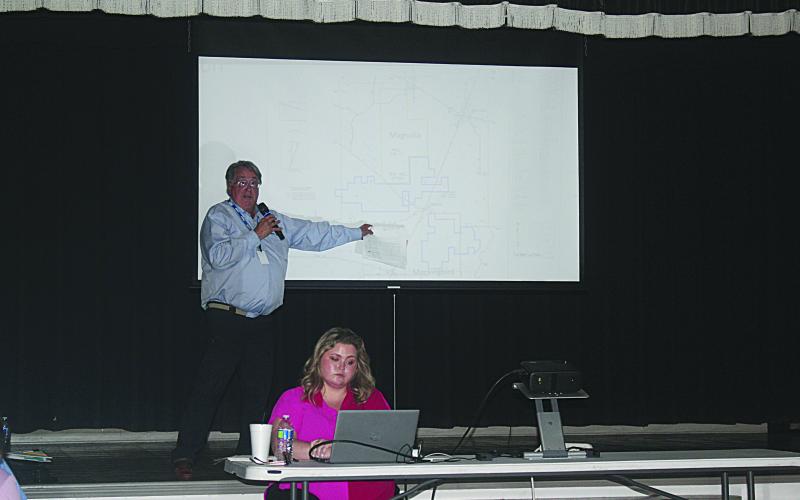 Standing is Michael Simms, Ph. D. (geology, hydrogeology) as he points out the location of the three currently proposed sites for carbon dioxide sequestration in Allen Parish. Seated is Emily Welch, who served as the moderator during the public hearing held Monday, April 28. (LSN photo by Tony Marks)