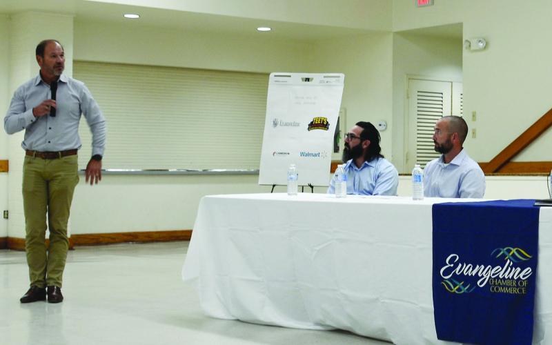 Cleco president and CEO Bill Fontenot (standing) delivers remarks during a meeting with the Evangeline Chamber of Commerce on Monday, September 26, at the Ville Platte Northside Civic Center. Seated from left are Cleco Energy Efficiency Consultant Gary Guidroz and Cleco Vice President of Customer Service Andre Guillory. (Photo by Mable Foreman)