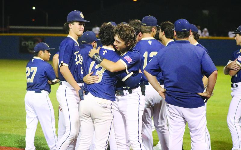 ALL HUGS  -  Members of the Sacred Heart baseball team gather on the field as senior Boyce Schexnider (13) and freshman John Aaron Soileau (10) share a hug after their quarterfinal loss against Covenant Christian. (Gazette photo by Tony Marks)