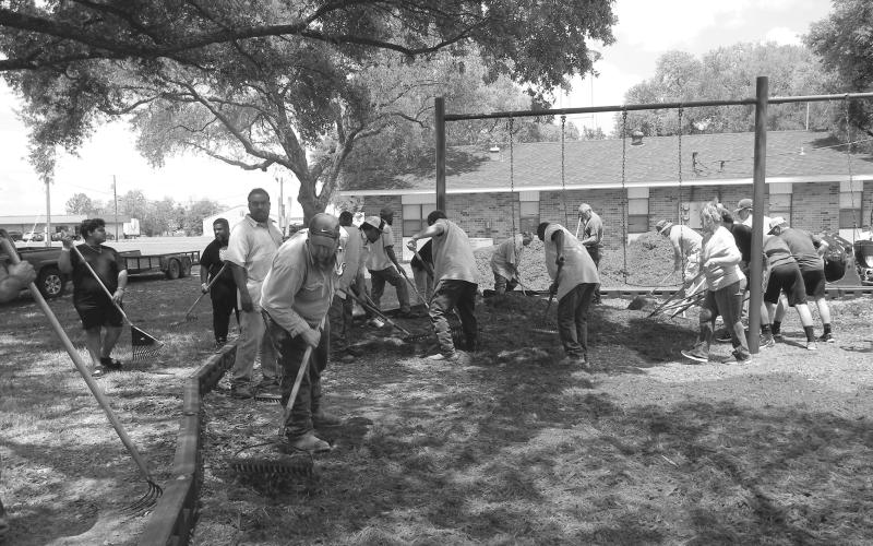 WORKING TOGETHER - On Friday, April 22, Mayor Ricky Fontenot, council members and several community volunteers worked together to replace the mulch at both town parks for the safety of the youth who will be utilizing the parks more during the coming the summer months. See more photos on Page 12. (Gazette photo by Heather Bogard)