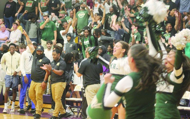 Members of the Mamou coaching staff and cheerleading squad, as well as other member of the Mamou community, celebrate after the Mamou Green Demons advanced to the state semifinals. With the win, the team moved on to play Marksville on Wednesday, March 11, at Burton Coliseum in Lake Charles. (Gazette photo by Tony Marks)