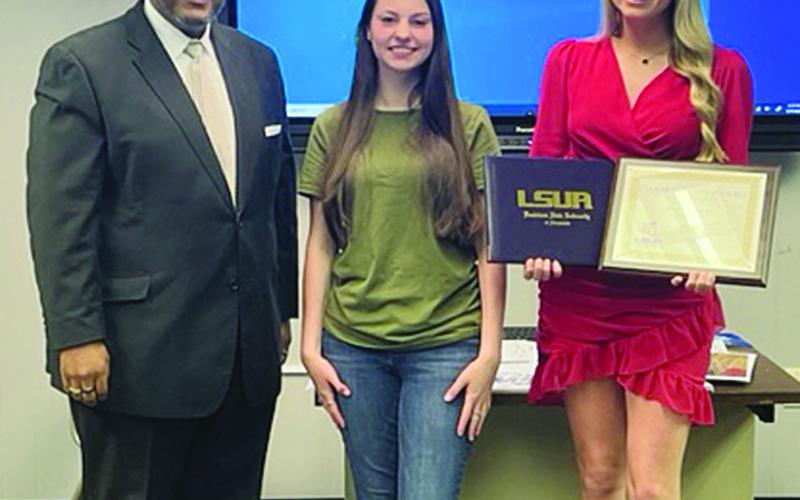 Superintendent Darwan Lazard is pictured on the left with Kaylie Granger (center), of Mamou High School, and Harlie Arnaud (right), of Pine Prairie High School. The students earned their dual enrollment associate degrees. Not present for the school board meeting on Wednesday, May 17, were Hanna Claire Manuel, Alli Chaumont, and Madison Forestier, of Basile High School. (Gazette photo by Tony Marks)