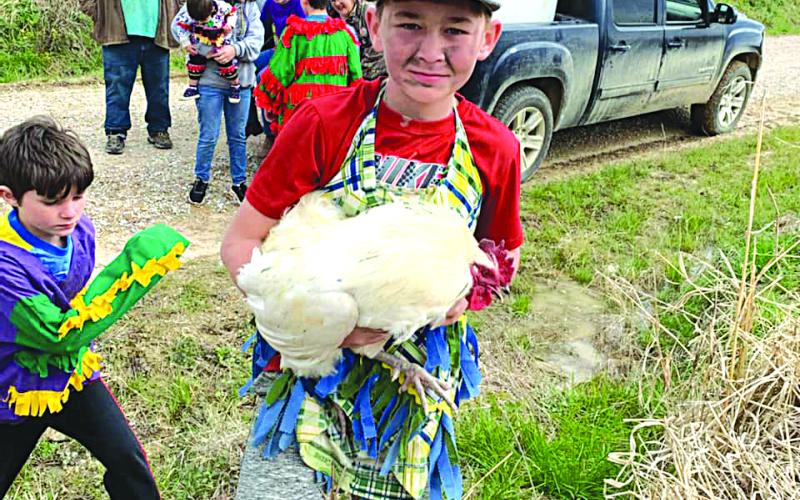 Wesley Matt is shown above with his prized chicken following a chase during the 2022 Duralde Children’s Mardi Gras run.