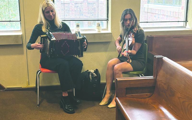 Juliane Mahoney (left) and Renee Reed (right), of The Holiday Playgirls, perform during the French meeting held Tuesday, December 10. (Gazette photo by Tony Marks)