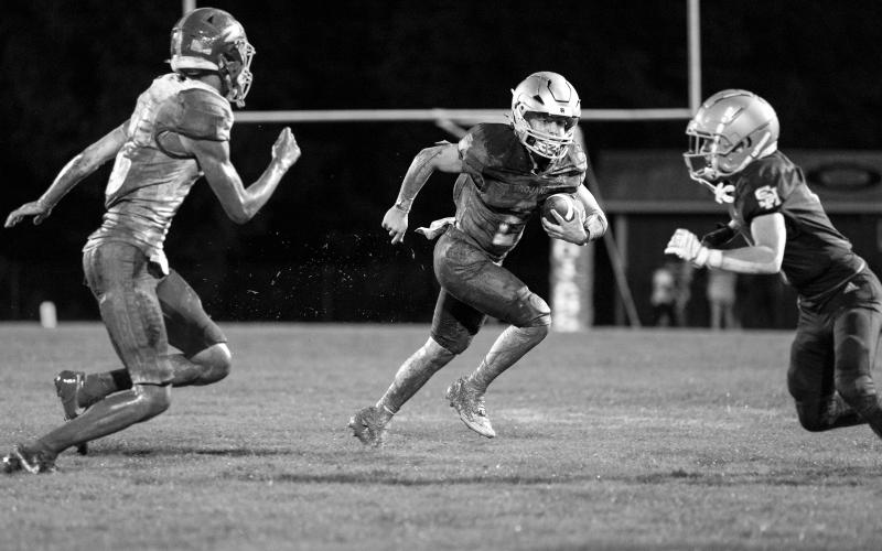 Trojan quarterback Ellis Fusilier (2) looks to pick up positive yardage in a win against Oakdale to open the football season. (Photo by Angela deVille)