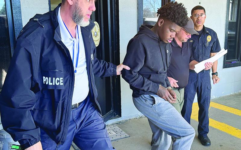 Mamou Assistant Chief of Police Caleb Semien (left) and Officer Steven Ardoin (right) escort Dorian Thomas (center) out of the police station. Also pictured is Mamou Chief of Police Pat Hall. (Photo submitted)