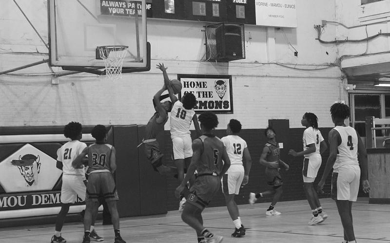 Mamou’s Tyrian Broussard (10) attempts to block a shot in the Green Demons’ game against Eunice. (Gazette photo by Rhett Manuel)