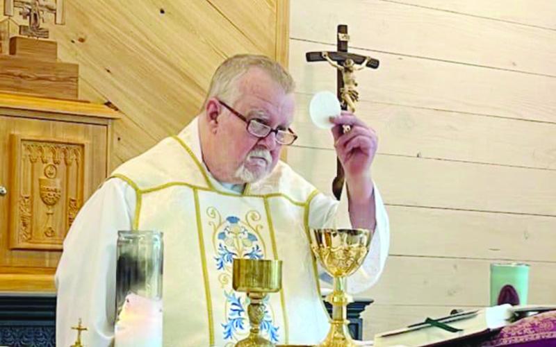 Fr. Greg Downs, of St. Peter Catholic Church in Pine Prairie and St. Theresa Catholic Church in St. Landry, is pictured as he elevates the Blessed Sacrament during a recent Mass. (Photo courtesy of St. Peter St. Theresa)