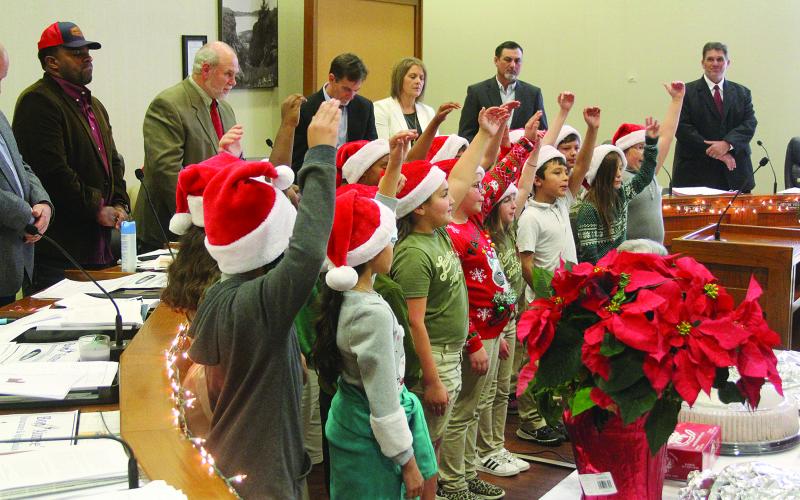 French Immersion students sing Christmas carols in French during the annual French meeting of the Evangeline Parish Police Jury held Tuesday, December 14. The students also led the Pledge of Allegiance in French. Pictured from left in the back are Police Jurors Ryan “LeDay” Williams and Eric Soileau, Secretary-Treasurer Donald Bergeron, and Police Jurors Leila Thrasher, Ryan Ardoin, and Kevin Veillon. (Gazette photo by Tony Marks)