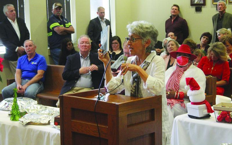 Amanda LaFleur Giambrone holds up a copy of a new book containing stories of Marion Marcotte during the French meeting held Tuesday, December 14. (Gazette photo by Tony Marks)