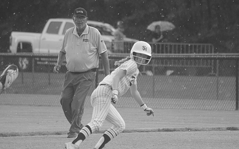 With the rain beginning to fall, Averie Pitre (7) attempts to get back safely to the first base bag in Sacred Heart’s playoff game against Glenbrook that was suspended on Tuesday. The game resumed on Wednesday at 2 p.m. (Gazette photo by Tony Marks)