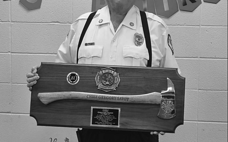 Acadia-Evangeline Fire Chief Greg Savoy shows off his retirement plaque.