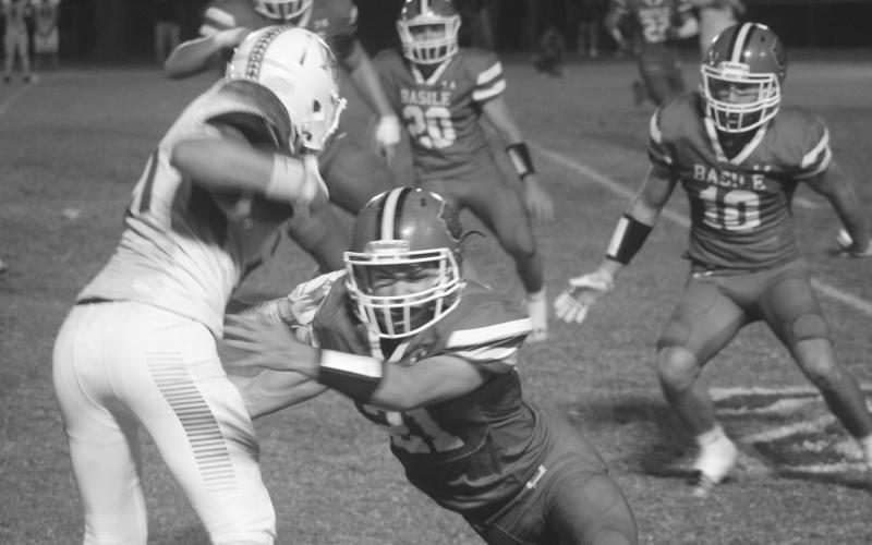 Basile’s Kye Smith (21) attempts to make a stop against a Hamilton Christian playmaker in the Bearcats’ 39-13 home loss against the Warriors. (Gazette photo by Tony Marks)