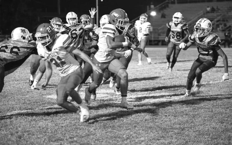 Basile’s Brian Hardy gallops past the Warrior line with some assistance from Kye Smith (21) during last week’s regular season finale. (Photo by Tonya Ortego)