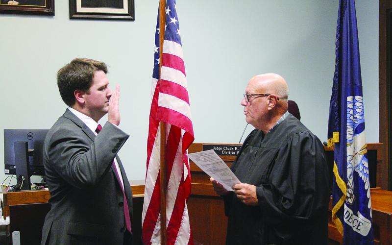 Chauncey Joseph (CJ) Hesnor (left) takes the oath of office from the honorable Judge Chuck West of the 13th Judicial Court. Hesnor was sworn-in as the newest assistant district attorney. (Gazette photo by Tony Marks)