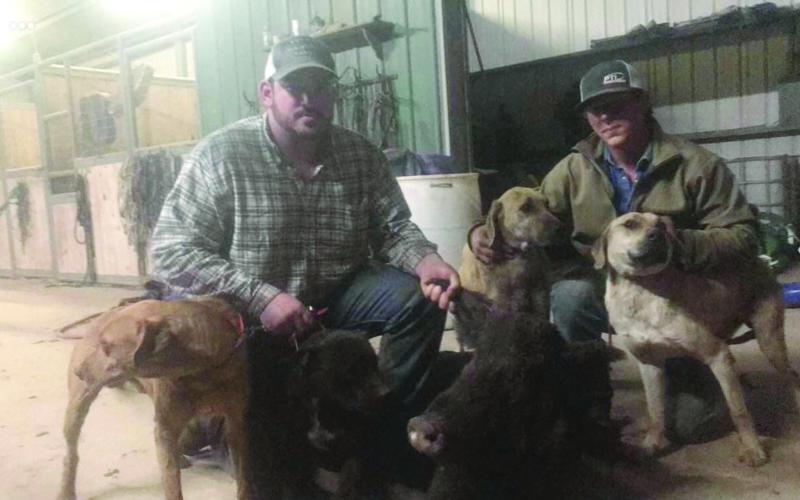 Wacen Fontenot (left) is pictured with Garrett Soileau (right) and their dogs after a pig hunt in Gold Dust. (Photo courtesy of Wacen Fontenot)