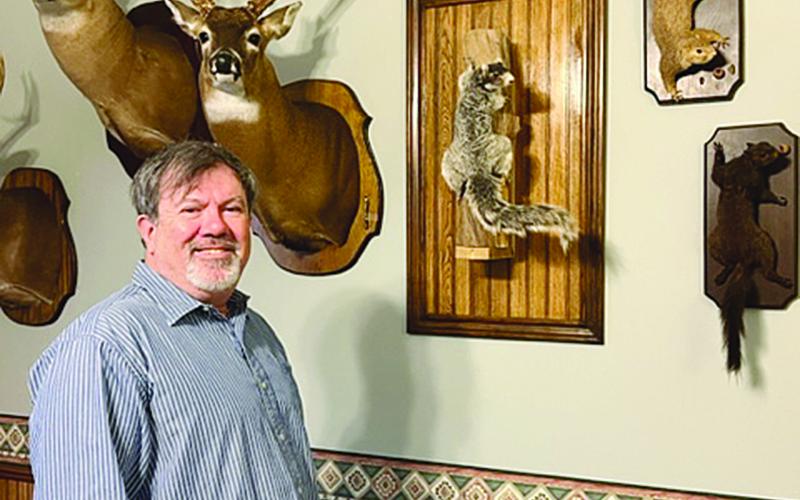 Ville Platte attorney Daniel Barzare is pictured with deer heads and squirrels that are mounted inside his law office. (Gazette photo by Tony Marks)