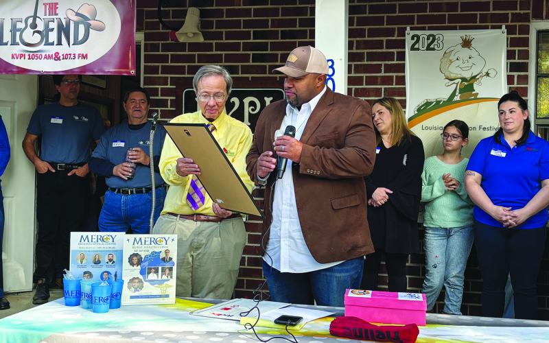 Ville Platte Mayor Ryan LeDay Williams (right) reads a proclamation which was presented to the station’s General Manager Mark Layne (left). (Gazette photos by Heather Bogard)