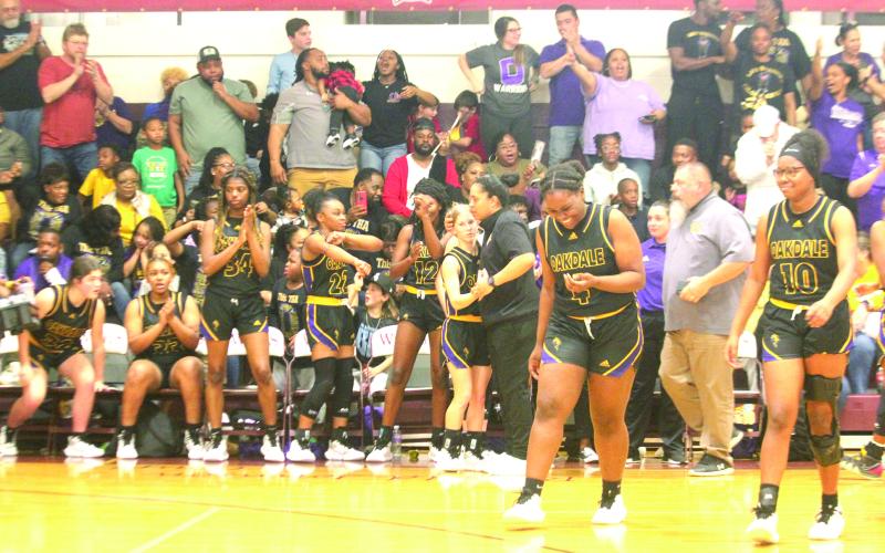 Ville Platte native and head coach of the Oakdale Lady Warriors Renotta Edwards (center right) celebrates with her team’s only senior Marlee Hart (center left) after defeating top seeded White Castle in the LHSAA Girls’ Basketball Quarterfinals. With the win, Edwards advanced to the former Top 28 for the first time in her playing/ coaching career. (LSN photo by Tony Marks)