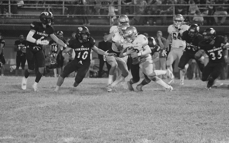 Trojan running back Jude Hebert (23) looks to turn a corner for additional yards in Sacred Heart’s 40-6 loss to Opelousas Catholic Thursday night. (Gazette photo by Rhett Manuel)