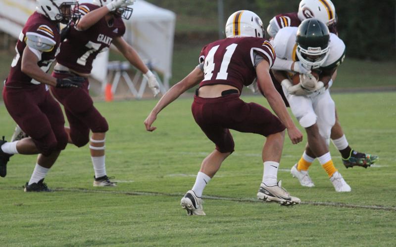 Christian Broussard (10) fights to stay on his feet as he attempts to gain positive yardage for Mamou in the Green Demons’ loss to Grant. Mamou now heads to Beau Chene High School tonight. (Gazette photo by Tony Marks)