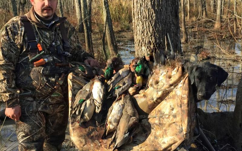 Luke Deville is pictured with ducks and his trusted hunting dog while on a recent hunting trip. To Deville, hunting keeps the bonds together among family and friends. (Photo courtesy of Luke Deville)