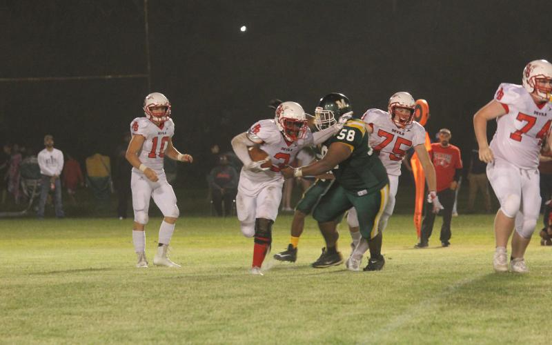 In a game against Port Barre earlier this season, Jaclarion Fontenot (58) attempts to make a tackle against Andre Tremble (3). The Green Demons now host Pine Prairie tomorrow night after earning a district opening win against Ville Platte last week. (Gazette photo by Tony Marks)