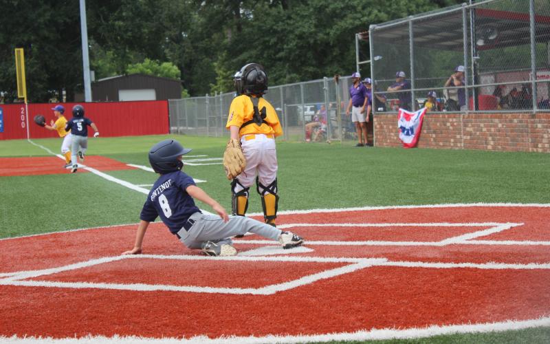 Ville Platte 7U Coach Pitch All-Star Jacques Fontenot slides into home plate to score a run in a 12-1 win over Benton in four innings last Thursday. The 7U All-Stars had a successful weekend, going 5-2 and finishing in third place in the state tournament to qualify for the World Series in Monroe. (Gazette photo by Rhett Manuel)